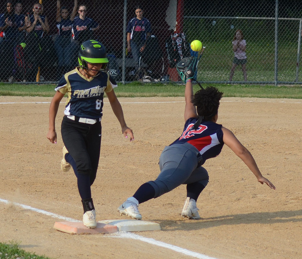 Pine Bush’s Jennifer Sorrentino is safe at first base as the ball gets away from Town of Wallkill’s Tia Fisher during a District 19 Senior softball game on July 5.